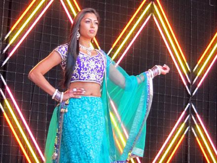 Fashion show participant in a traditional blue outfit.