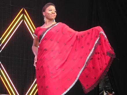Fashion show participant in a traditional red outfit.